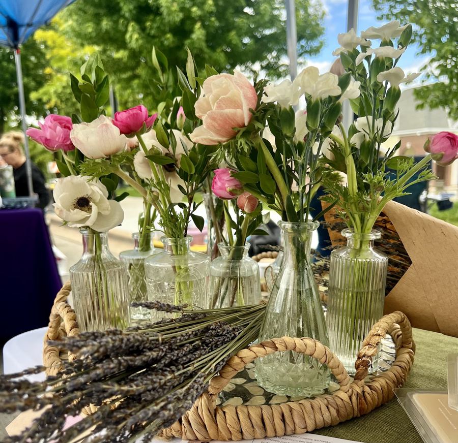Fresh flowers in glass vases at a vendor stand