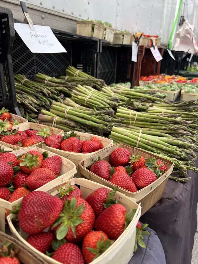 Strawberries and asparagus stacked on a stand
